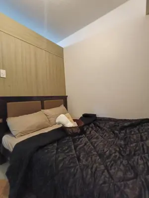 a bedroom with a bed with a black comforter at Shore moa view in Manila
