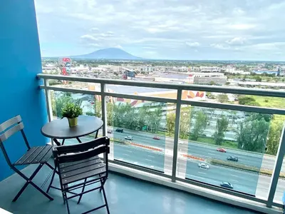 a table and chair on a balcony with a view at SM Bicutan Condo by Santorini in Manila