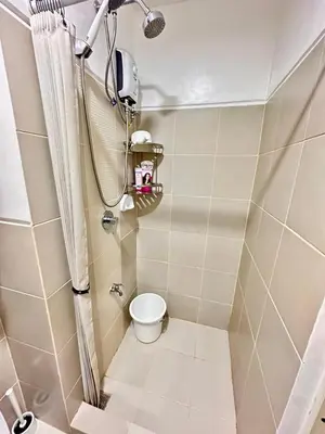 a small bathroom with a toilet and a shower at Paradise Staycation at South in Manila