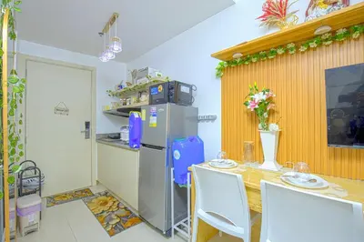 a kitchen with a table and a refrigerator at Paradise Staycation at South in Manila