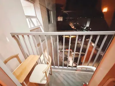 a balcony with a white railing and a table and chairs at Paradise Staycation at South in Manila