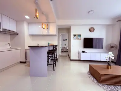 a kitchen and living room with a table and a counter at Bright & Cozy High-Rise Condo in Pulong Cacawate