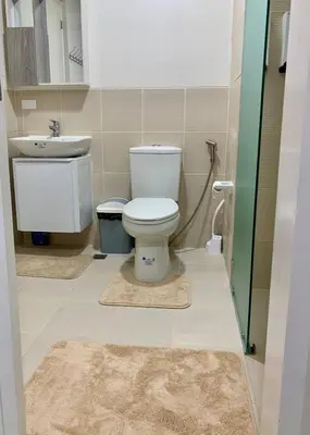 a bathroom with a toilet and a sink at Bright & Cozy High-Rise Condo in Pulong Cacawate