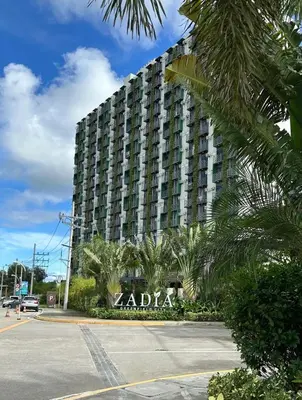 a large building with a sign in front of it at Bright & Cozy High-Rise Condo in Pulong Cacawate