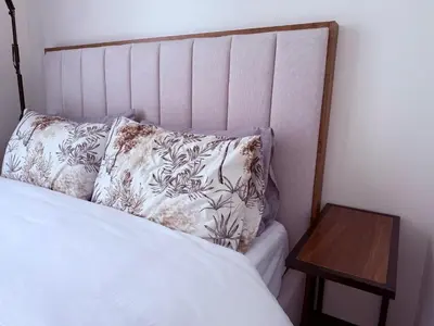 a bed with a pillow and a wooden table at Bright & Cozy High-Rise Condo in Pulong Cacawate