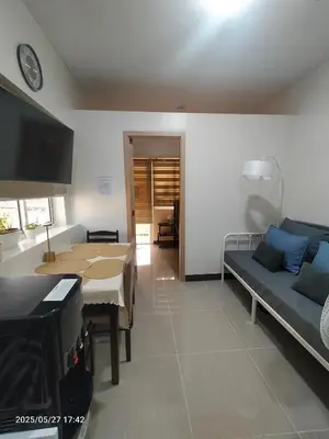 a living room with a table and a couch at 1123 Field Res Condo by Bambie free drinking water in Manila