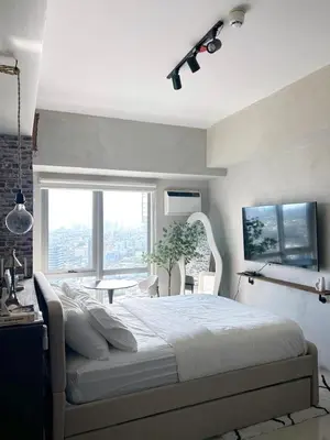 a bedroom with a large bed and a window at Trescape Studio in Manila