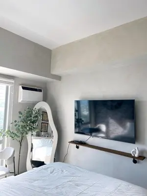 a bedroom with a white bed and a mirror at Trescape Studio in Manila