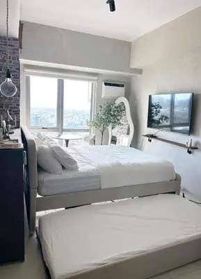 a bedroom with two beds and a window at Trescape Studio in Manila