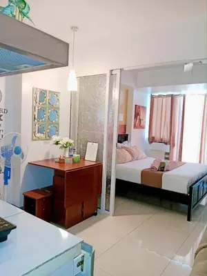 a bedroom with a bed and a desk with a desk at SM Condotels by Maui in Manila