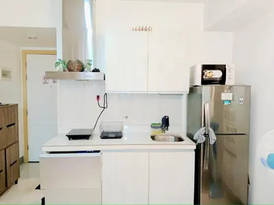 a white kitchen with a sink and a refrigerator at SM Condotels by Maui in Manila