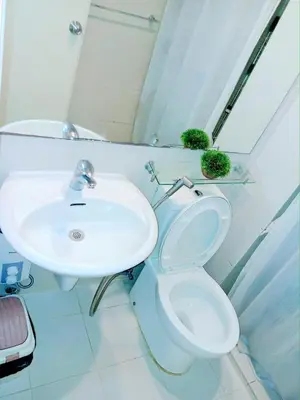 a bathroom with a white toilet and a sink at SM Condotels by Maui in Manila