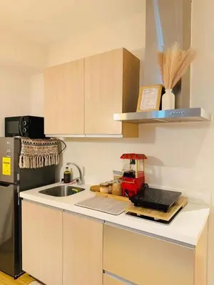 a kitchen with a counter with a sink and a refrigerator at SM Condotels by Maui in Manila