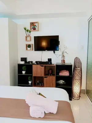 a bedroom with a bed and a flat screen tv at SM Condotels by Maui in Manila
