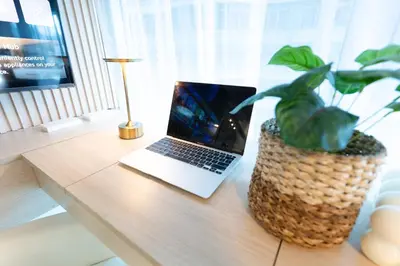 a laptop sitting on a table with a potted plant at 2mins to Malls, Unli Full Body Massage, Eastwood Le Grand 3 in Manila