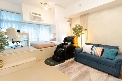 a bedroom with a couch and a bed and a chair at 2mins to Malls, Unli Full Body Massage, Eastwood Le Grand 3 in Manila