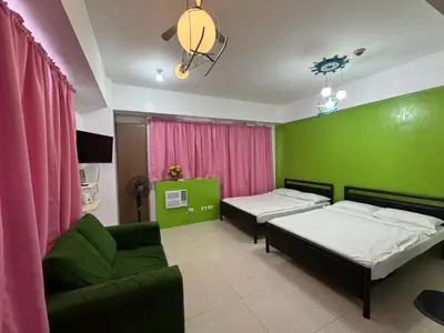 a room with two beds and a couch in it at One Palm Tree Condo in Manila