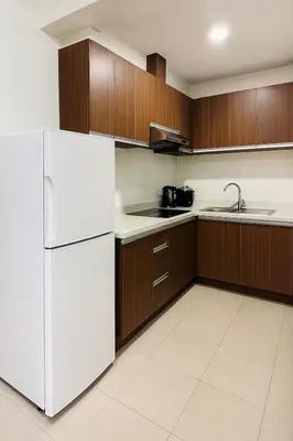 a kitchen with a white refrigerator and wooden cabinets at \u5eb7\u5bbf \u6ec4\u6d77\u5c45 Sea Horizon in Sampong