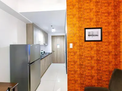 a kitchen with a brick wall and a refrigerator at 1BR Condotel with Balcony at FAME Residences #FM04-1 in Manila