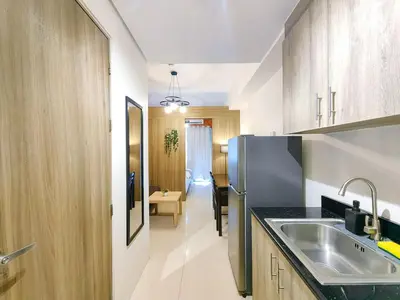 a kitchen with a sink and a refrigerator at 1BR Condotel with Balcony at FAME Residences #FM04-1 in Manila