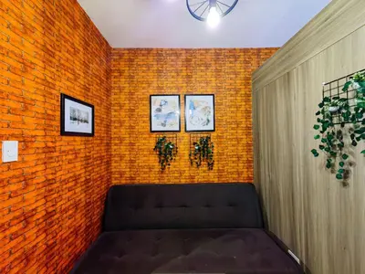 a room with a couch against a brick wall at 1BR Condotel with Balcony at FAME Residences #FM04-1 in Manila