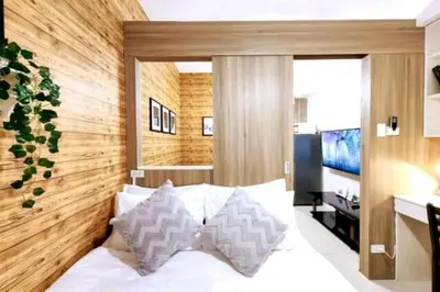 a bedroom with a white bed with two pillows at 1BR Condotel with Balcony at FAME Residences #FM05-1 in Manila