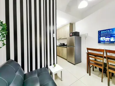 a living room with a couch and a kitchen at 1BR Condotel with Balcony at FAME Residences #FM06-1 in Manila