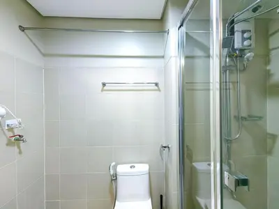 a bathroom with a toilet and a glass shower at 1BR Condotel with Balcony at FAME Residences #FM07-1 in Manila