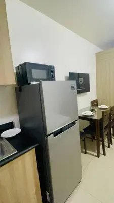 a kitchen with a stainless steel refrigerator and a table at Shore Residences Tower D in Manila