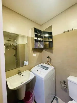 a bathroom with a sink and a washing machine at Shore Residences Tower D in Manila