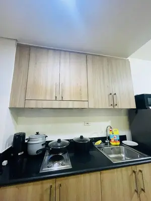 a kitchen with two pots and pans on a stove at Shore Residences Tower D in Manila