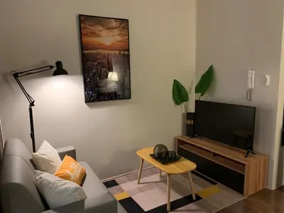 a living room with a couch and a flat screen tv at Makati City Ayala Ave Extension Condo with Fast Internet in Manila