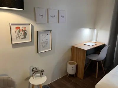a room with a desk and a bed and a table at Makati City Ayala Ave Extension Condo with Fast Internet in Manila