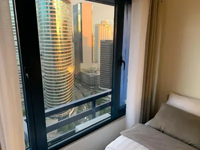 a bedroom with a window with a view of a city at Makati City Ayala Ave Extension Condo with Fast Internet in Manila