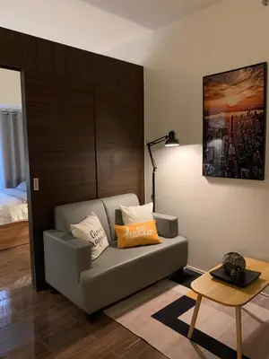 a living room with a couch and a bed at Makati City Ayala Ave Extension Condo with Fast Internet in Manila