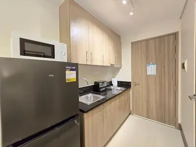 a kitchen with a stainless steel refrigerator and a sink at 1BR Condotel with Balcony at FAME Residences #FM10-1 in Manila