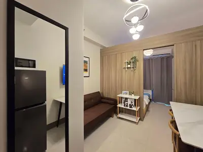 a living room with a couch and a table at 1BR Condotel with Balcony at FAME Residences #FM10-1 in Manila