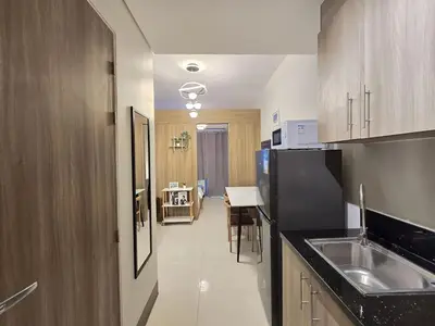 a kitchen with a sink and a black refrigerator at 1BR Condotel with Balcony at FAME Residences #FM10-1 in Manila