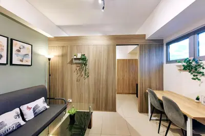 a dining room and living room with a table and chairs at 1BR Condotel with Balcony at FAME Residences #FM11-1 in Manila
