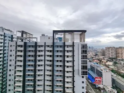 a tall white building with a view of a city at 1BR Condotel with Balcony at FAME Residences #FM11-1 in Manila