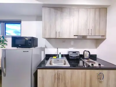 a small kitchen with a sink and a refrigerator at 1BR Condotel with Balcony at FAME Residences #FM11-1 in Manila