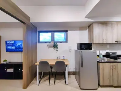 a small kitchen with a table and a refrigerator at 1BR Condotel with Balcony at FAME Residences #FM11-1 in Manila