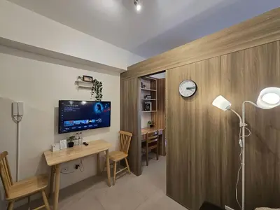 a room with a desk and a clock on a wall at 1BR Condotel with Balcony at FAME Residences #FM14-1 in Manila