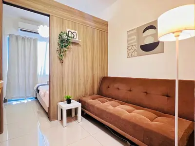 a living room with a couch and a bed at 1BR Condotel with Balcony at FAME Residences #FM15-1 in Manila