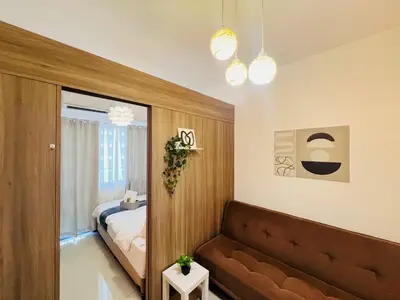 a living room with a couch and a bed at 1BR Condotel with Balcony at FAME Residences #FM15-1 in Manila