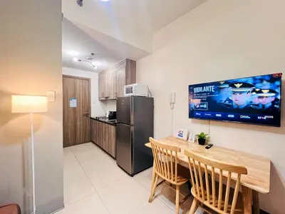 a kitchen and dining room with a table and a refrigerator at 1BR Condotel with Balcony at FAME Residences #FM15-1 in Manila