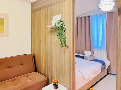 a small room with a bed and a couch at 1BR Condotel with Balcony at FAME Residences #FM18-1 in Manila