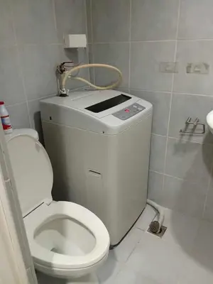 a bathroom with a white toilet and a sink at David staycation in Manila