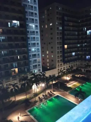 a view of a swimming pool at night with buildings at David staycation in Manila