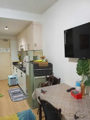 a kitchen with a table and a tv in a room at David staycation in Manila